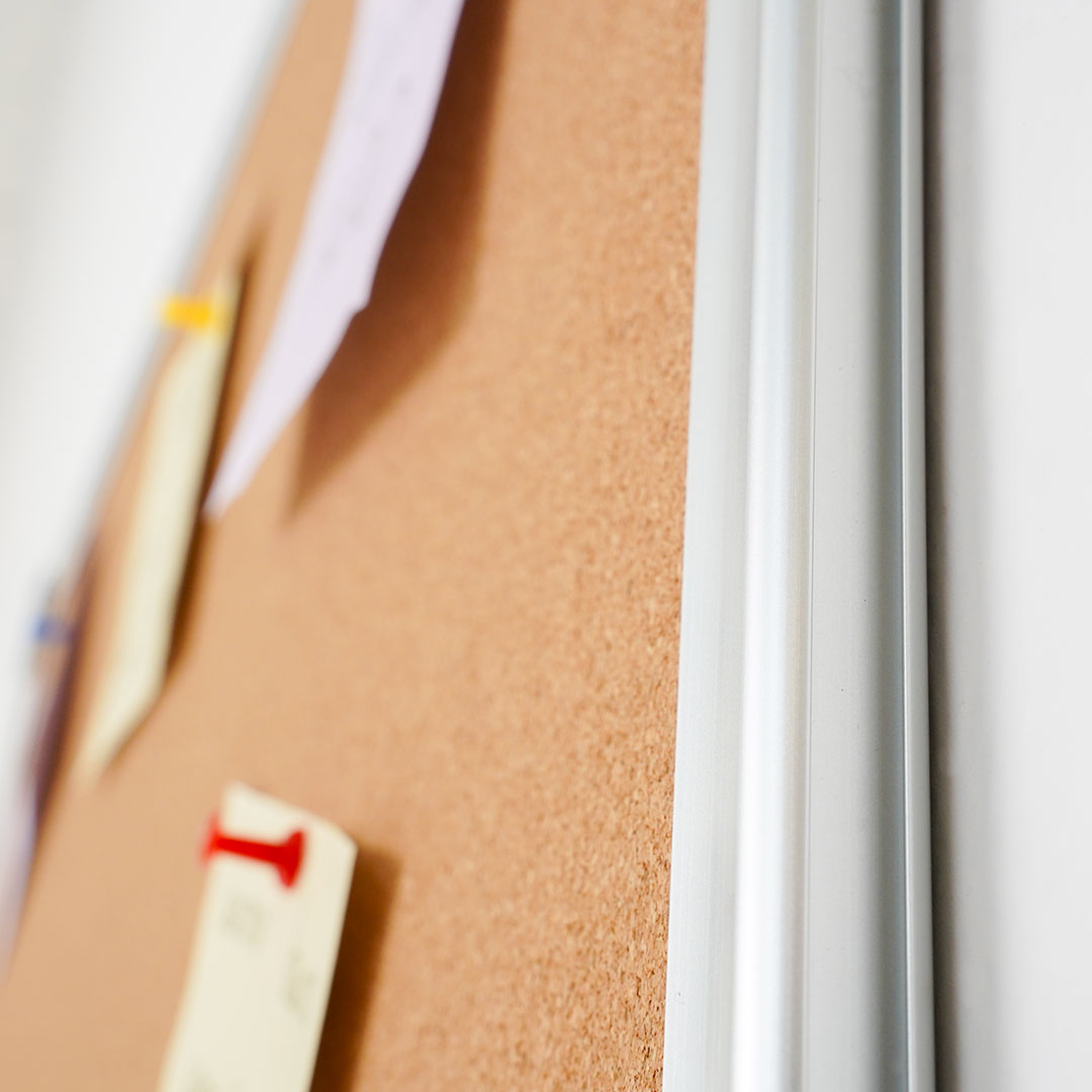 detalle de fijacion de notas a pizarra de corcho